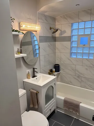 a bathroom with a sink toilet vanity and shower