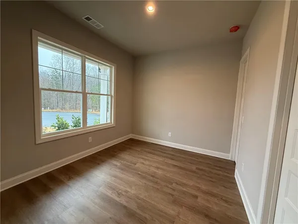 an empty room with wooden floor and windows