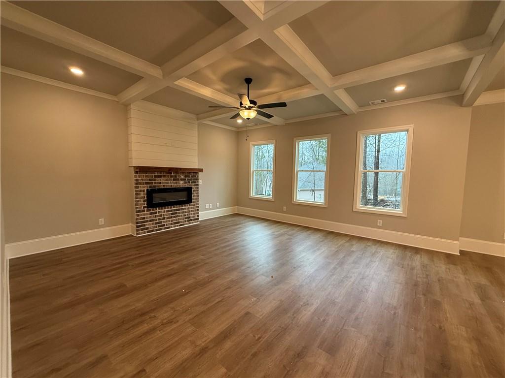 3838 Cheyenne Lane Jefferson, GA 30549 - Photo 6 of 29 an empty room with fireplace wooden floor and windows