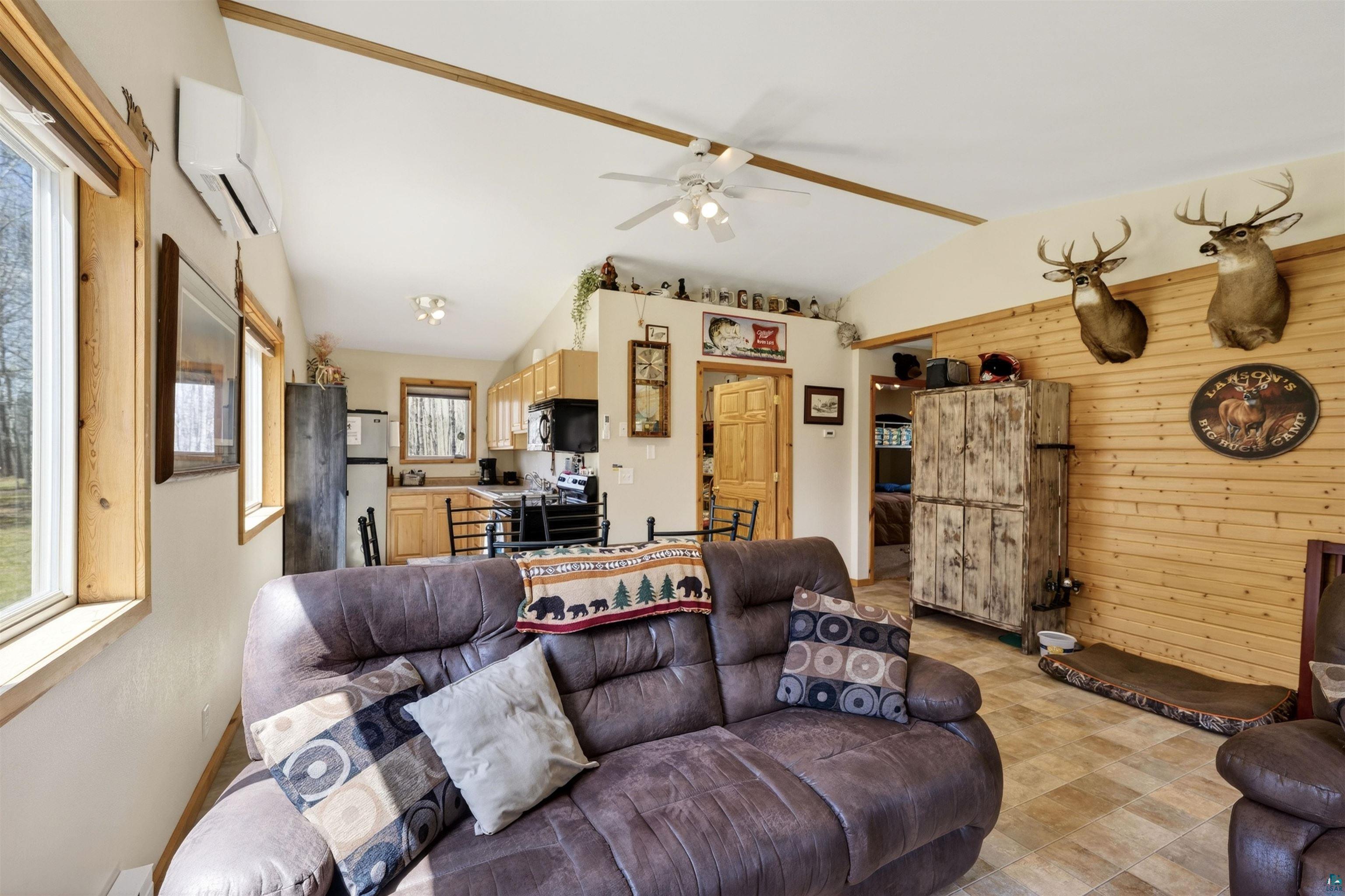 12235 East Crooked Lake Road Gordon, WI 54838 - Photo 12 of 48 Vaulted ceilings define this living space featuring natural wood paneling and trim, a ceiling fan, and a mini-split HVAC unit