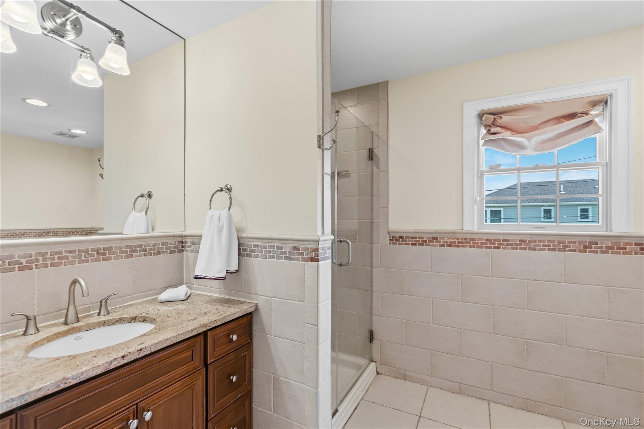 47 Syosset Circle Syosset, NY 11791 - Photo 20 of 30 a bathroom with a granite countertop sink a mirror and shower
