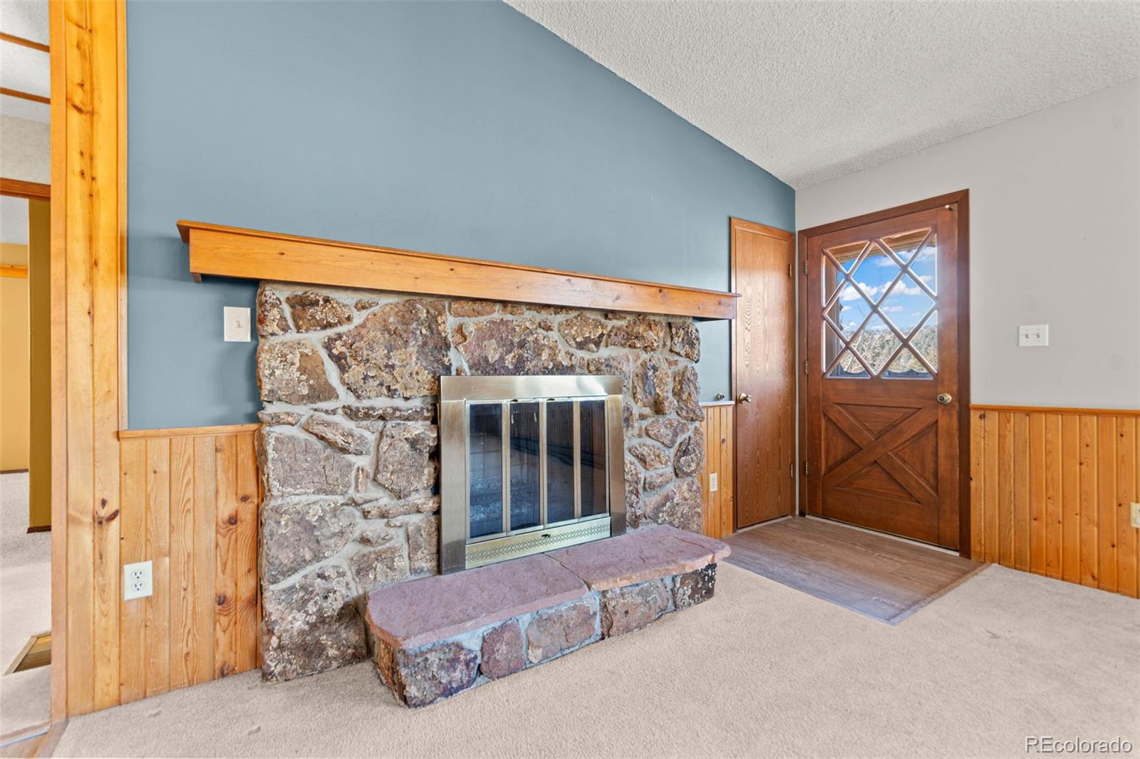 237 Homestead Road Bailey, CO 80421 - Photo 9 of 43 a living room with a fireplace and a large window