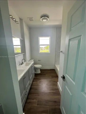a bathroom with a sink toilet and window