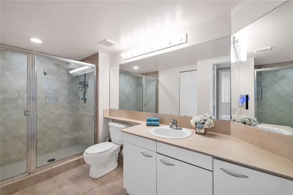 a bathroom with a double vanity sink toilet and shower