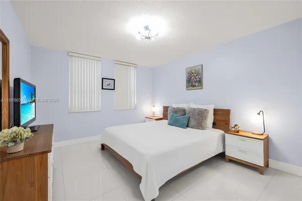 a bedroom with a bed and a potted plant