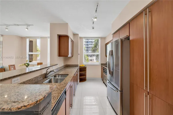 a kitchen that has a refrigerator a sink and a stove