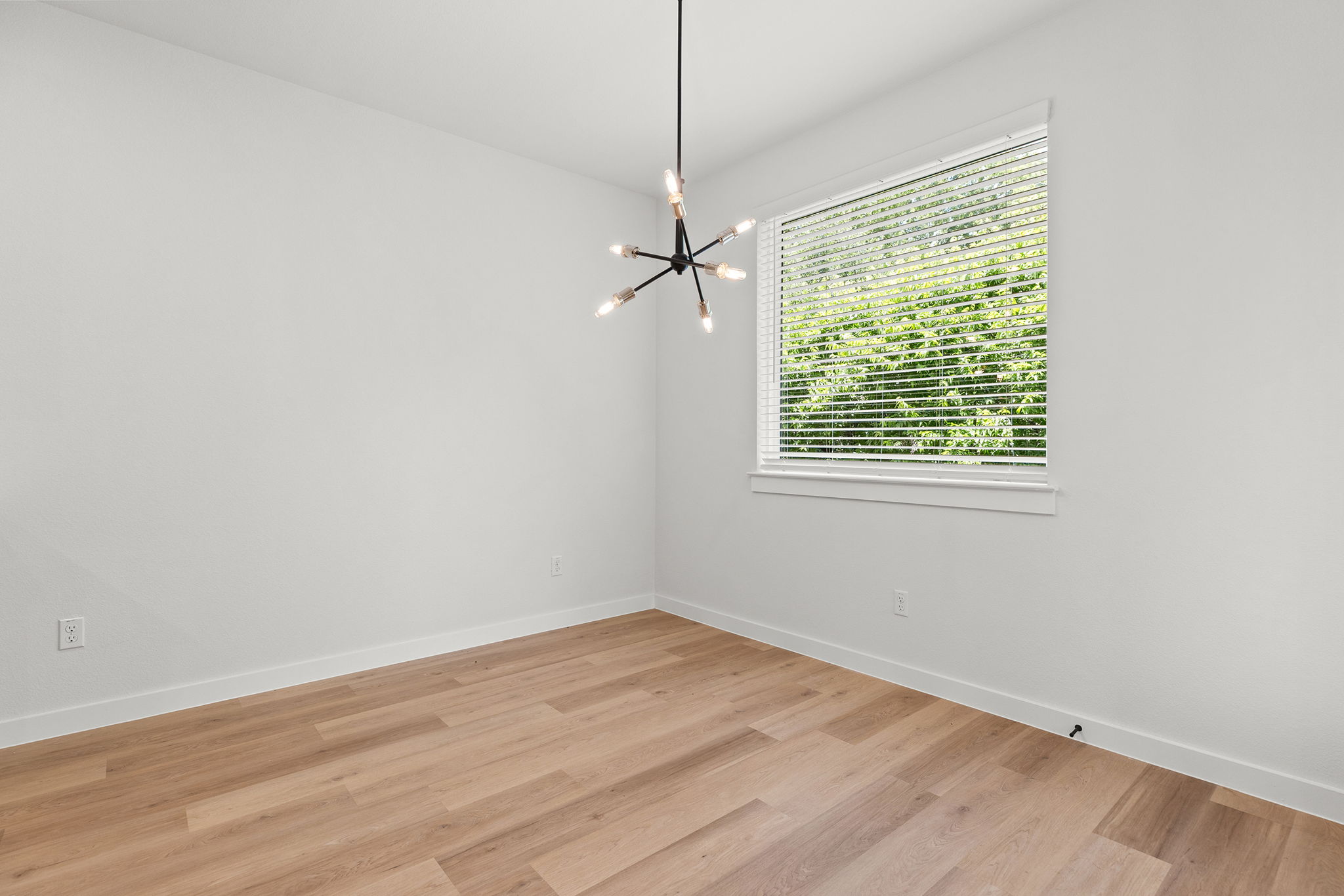 2600 Gattis School Road, Unit 1001 Round Rock, TX 78664 - Photo 15 of 40 Luminous room featuring polished wood flooring and an elegant contemporary light fixture.