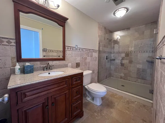 a bathroom with a sink a toilet and shower