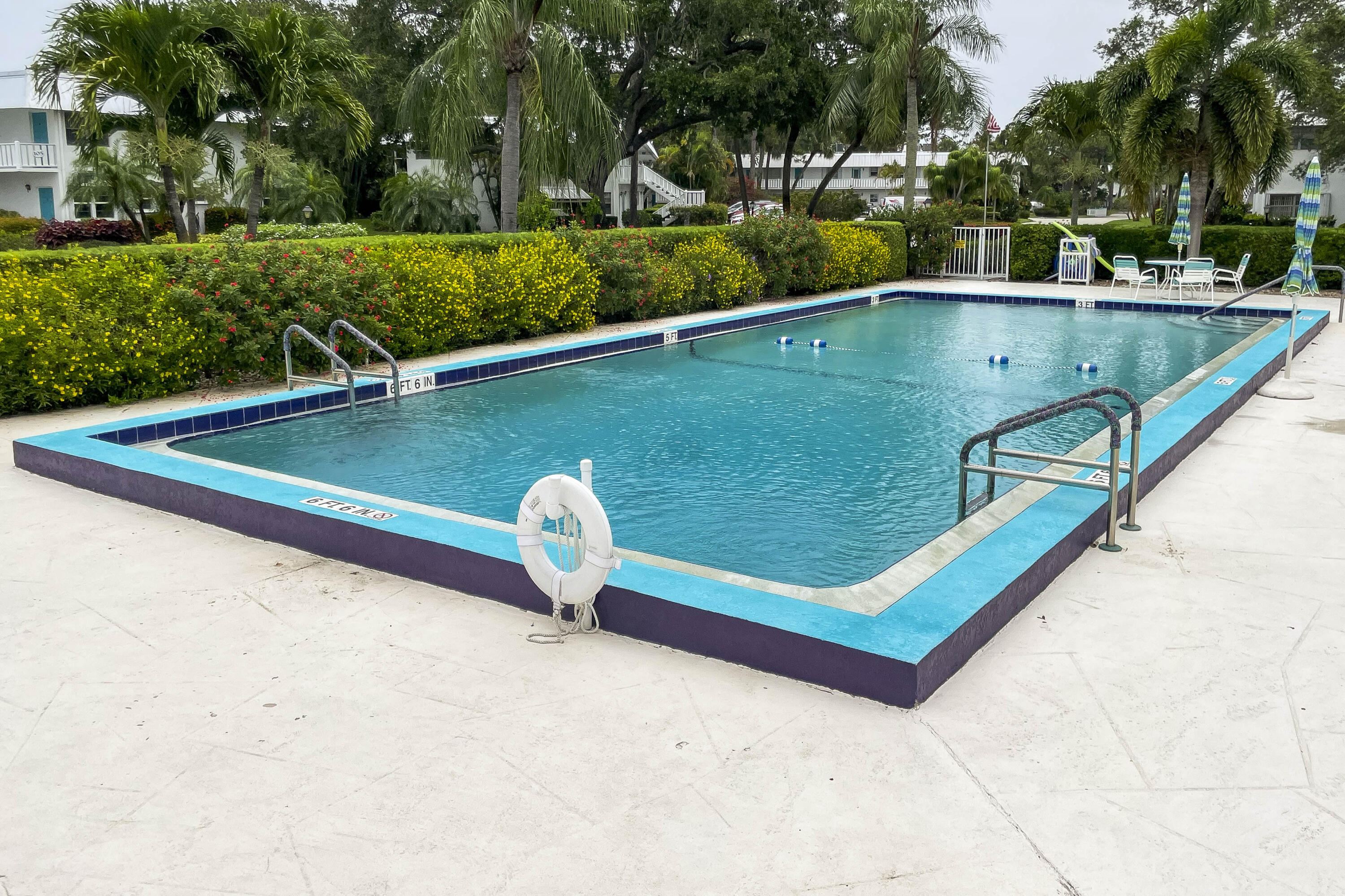 2929 Southeast Ocean Boulevard, Unit 1146 Stuart, FL 34996 - Photo 17 of 19 a view of a pool with a bench and trees