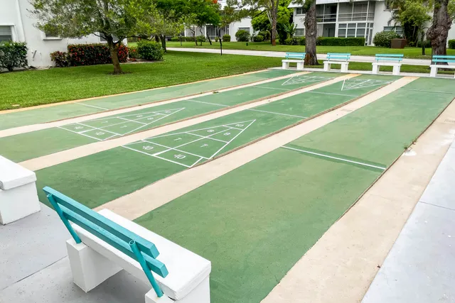 a view of a tennis ground with large trees