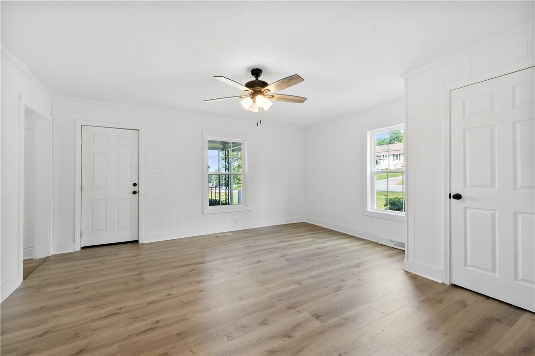 201 South 8th Street Easley, SC 29640 - Photo 19 of 28 Smooth wood-style flooring and bright vertical wall paneling define this versatile living area.