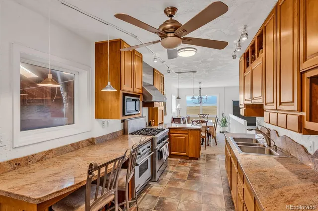 a kitchen with stainless steel appliances granite countertop a stove a sink and a microwave