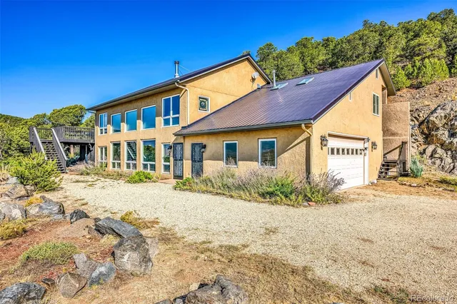 a view of a house with wooden deck and furniture