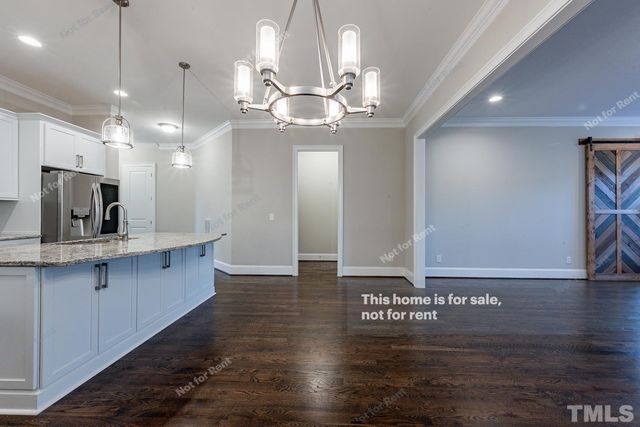 a view of a hallway with kitchen and chandelier