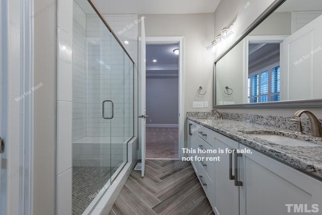 a bathroom with a granite countertop sink a mirror and shower