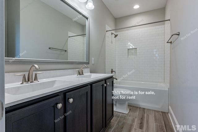 a bathroom with a sink a toilet a mirror and shower