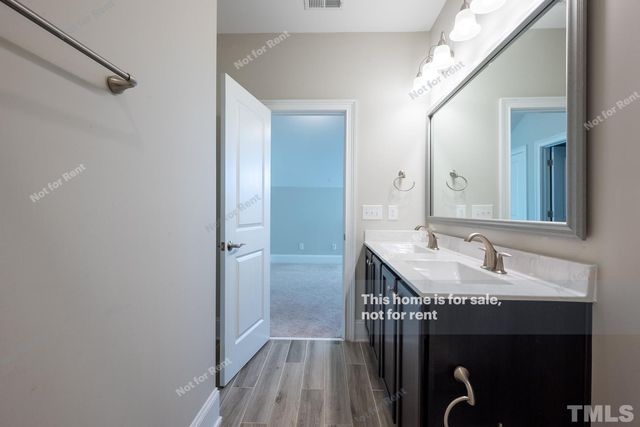 a en suite bathroom with a granite countertop sink a mirror and a shower