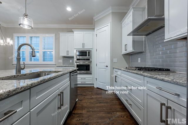 a kitchen with kitchen island granite countertop a sink stainless steel appliances and cabinets