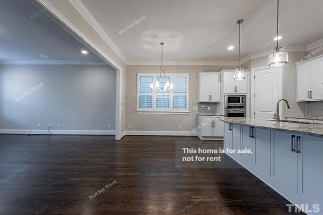 a kitchen with granite countertop a stove a sink and a wooden floors