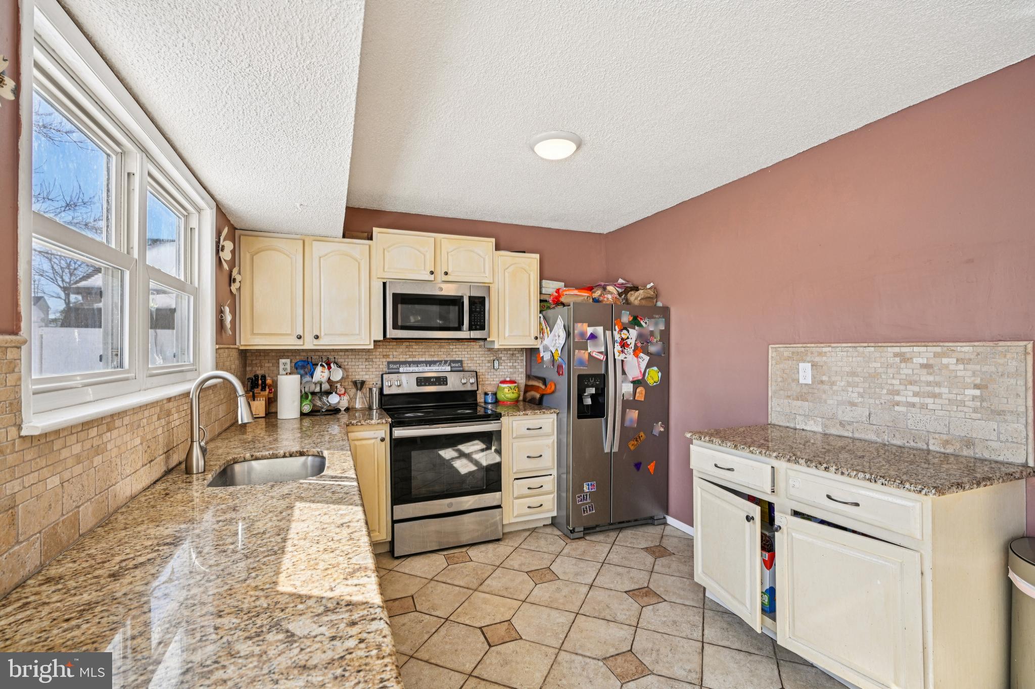 135 Windward Drive Barnegat, NJ 08005 - Photo 13 of 55 a kitchen with granite countertop a stove top oven microwave and cabinets