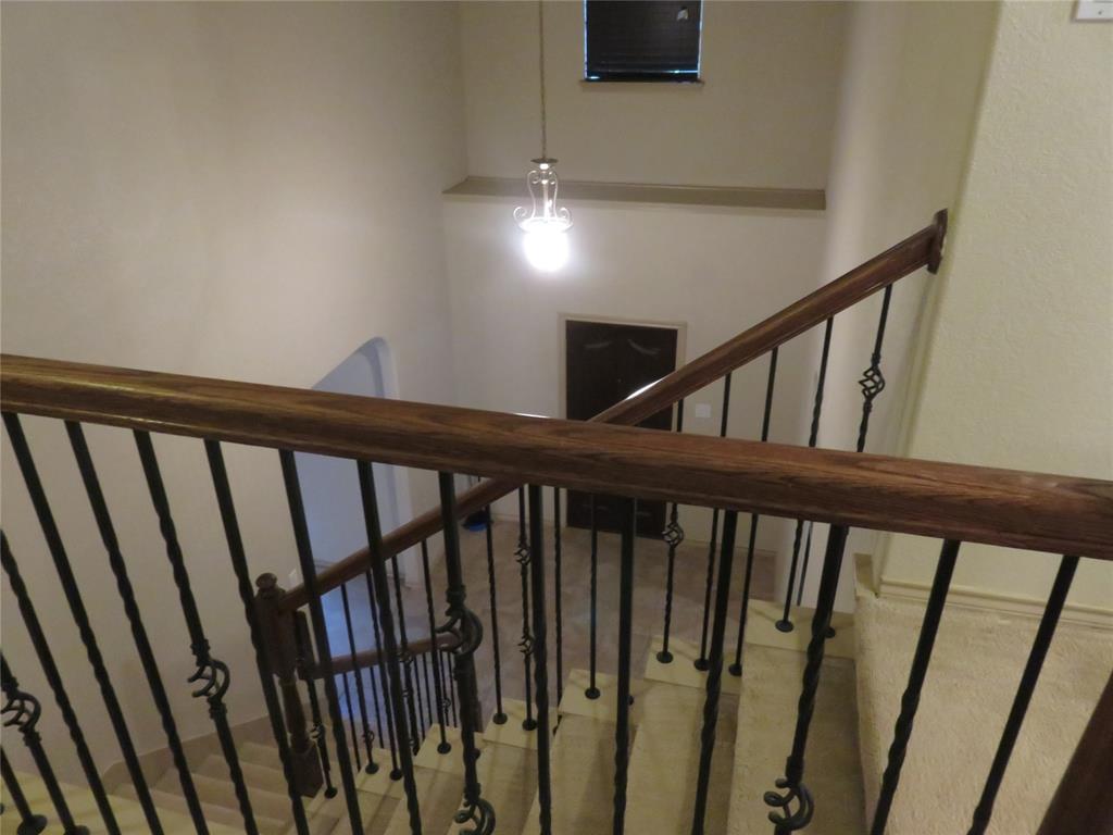 1122 Walter Stephenson Road Midlothian, TX 76065 - Photo 14 of 26 Staircase featuring wrought iron balusters with decorative elements, a polished wood handrail, and tiled steps