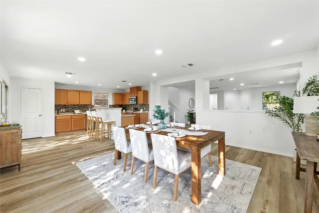 a kitchen with kitchen island granite countertop a refrigerator and white cabinets