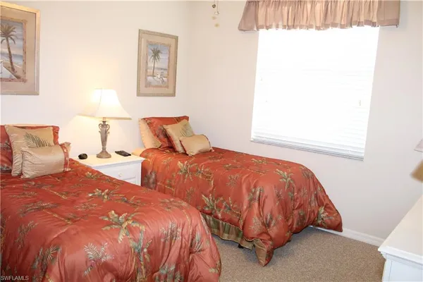 a bed sitting in a bedroom next to a window