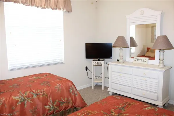 a bedroom with a bed window and a flat screen tv