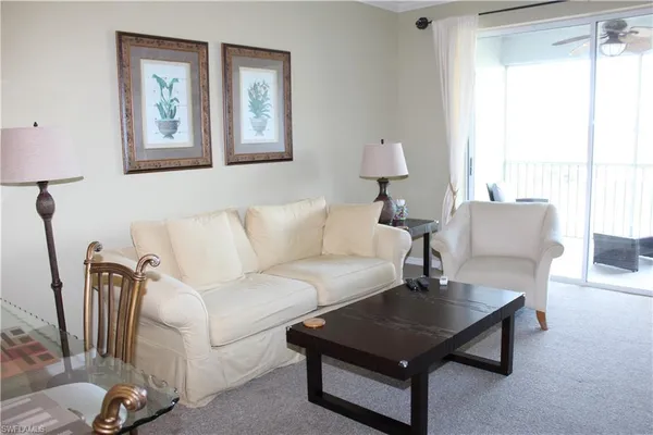 a living room with furniture a lamp and a window
