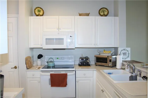 a kitchen with a sink a stove and cabinets