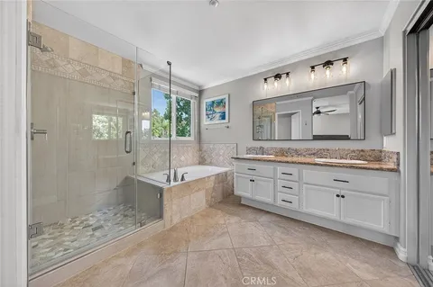 a spacious bathroom with a granite countertop sink mirror and shower