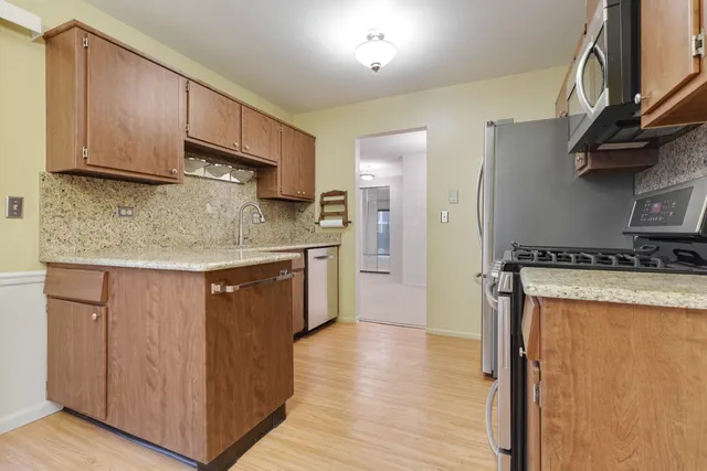 a kitchen with stainless steel appliances granite countertop a sink stove and refrigerator