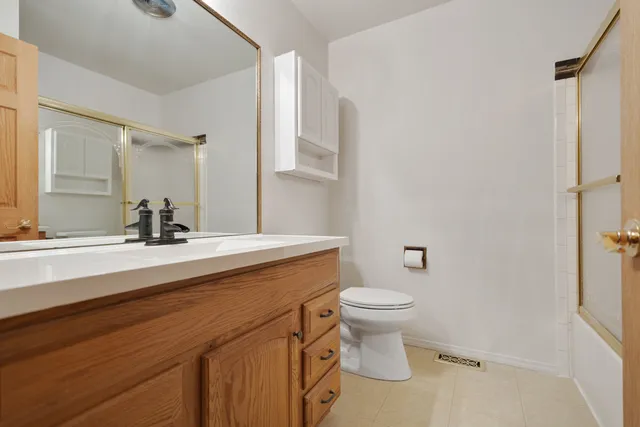 a bathroom with a sink a toilet a mirror and shower