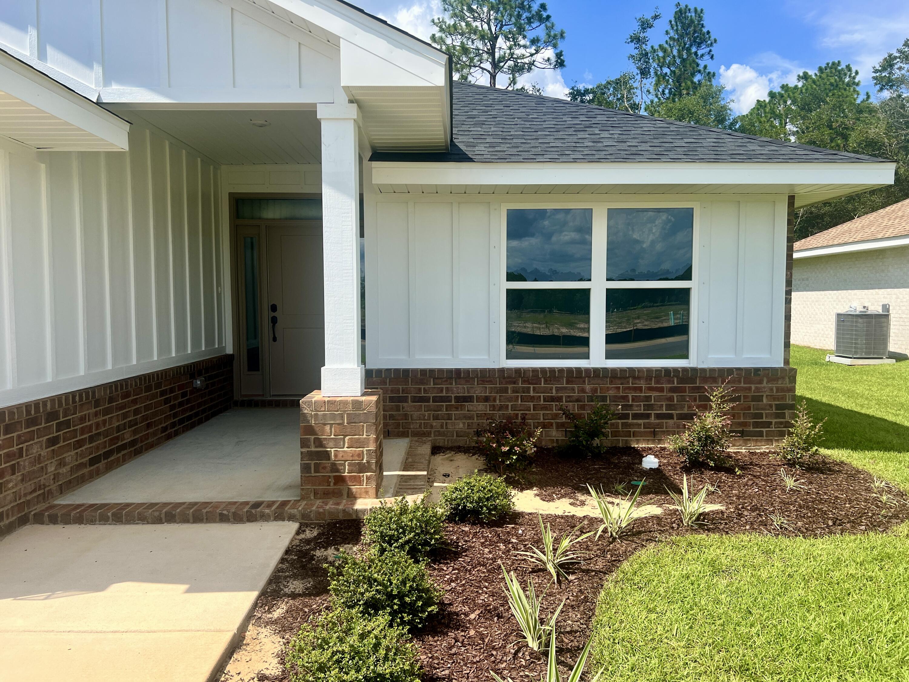 5283 Hidden Pines Circle Milton, FL 32583 - Photo 2 of 16 a front view of a house with garden