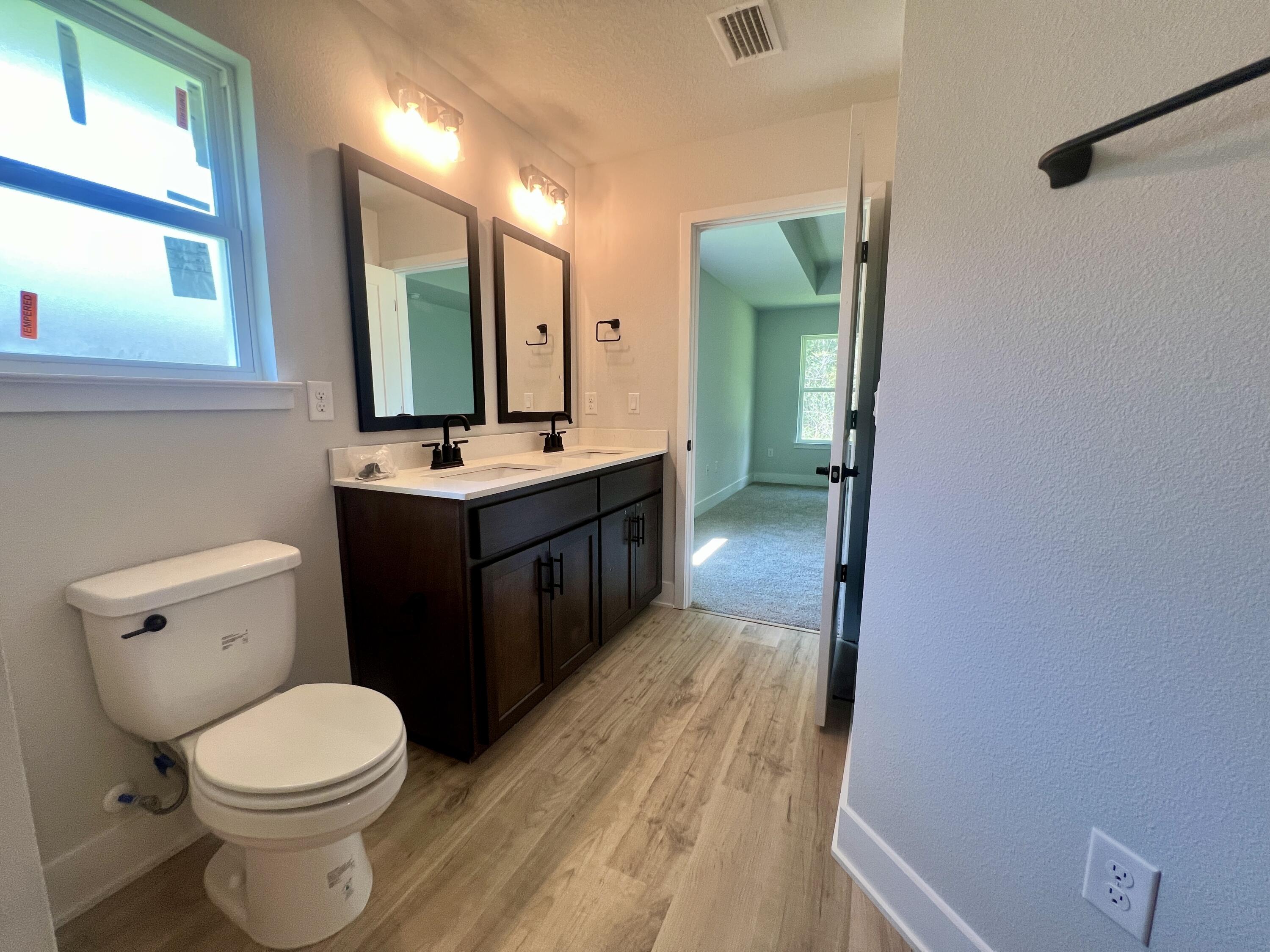 5283 Hidden Pines Circle Milton, FL 32583 - Photo 5 of 16 a bathroom with a toilet sink vanity and mirror