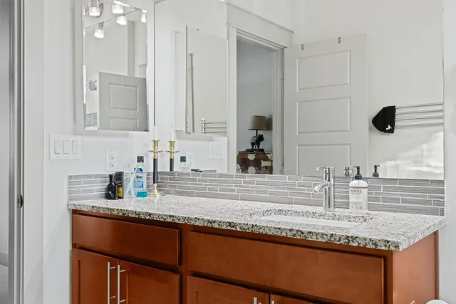 a bathroom with a granite countertop sink and a mirror