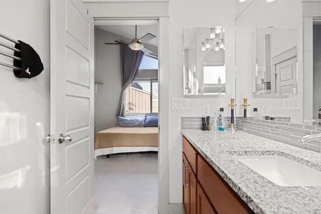 a spacious bathroom with a granite countertop sink a mirror and shower