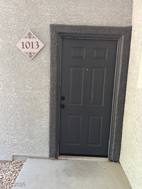 Doorway to property with stucco siding