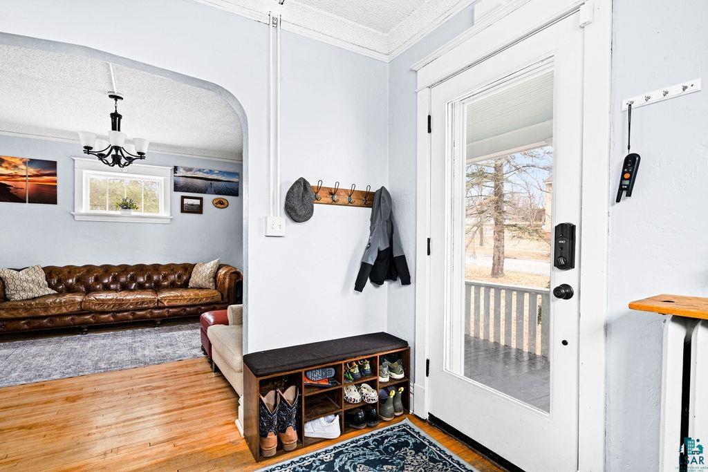 4608 Regent Street Duluth, MN 55804 - Photo 11 of 43 Foyer with crown molding, wood finished floors, arched walkways, and a textured ceiling