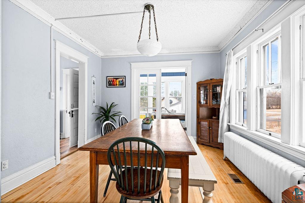 4608 Regent Street Duluth, MN 55804 - Photo 14 of 43 Dining room with light wood-style floors, visible vents, radiator, and ornamental molding