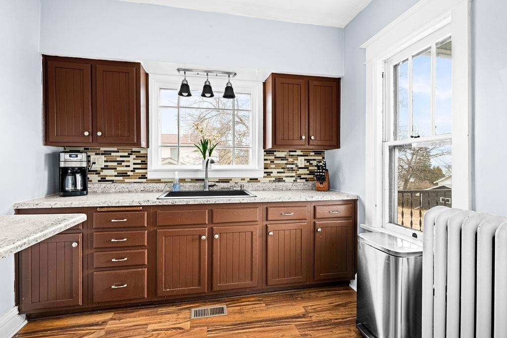 4608 Regent Street Duluth, MN 55804 - Photo 17 of 43 Kitchen featuring a sink, visible vents, tasteful backsplash, and radiator