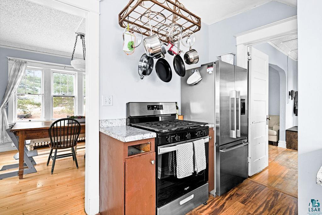 4608 Regent Street Duluth, MN 55804 - Photo 19 of 43 Kitchen featuring stainless steel appliances, a textured ceiling, ornamental molding, and light wood finished floors