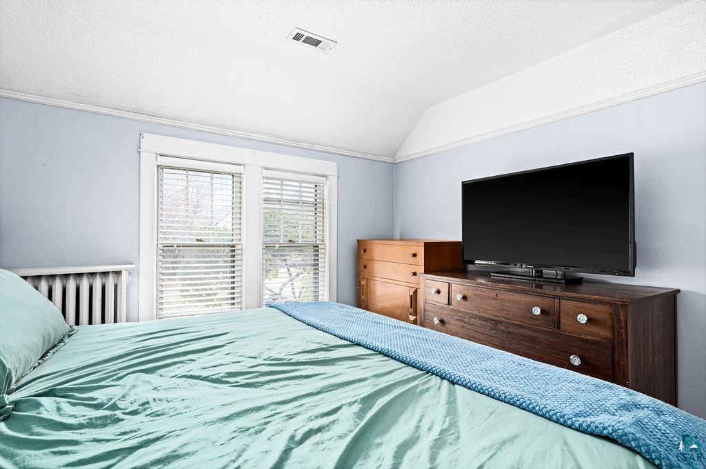 4608 Regent Street Duluth, MN 55804 - Photo 23 of 43 Bedroom featuring visible vents, a textured ceiling, radiator, and vaulted ceiling