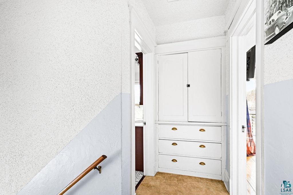 4608 Regent Street Duluth, MN 55804 - Photo 29 of 43 Hallway with light colored carpet, a textured wall, and a textured ceiling