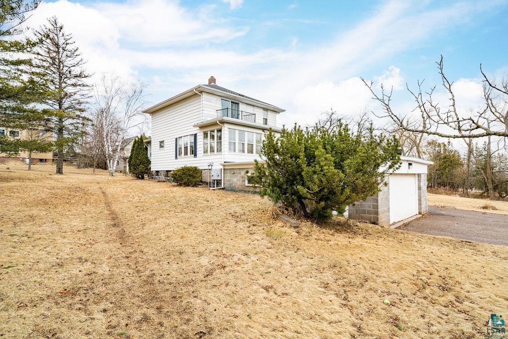 4608 Regent Street Duluth, MN 55804 - Photo 4 of 43 View of front facade with an outbuilding, driveway, a garage, a balcony, and a chimney