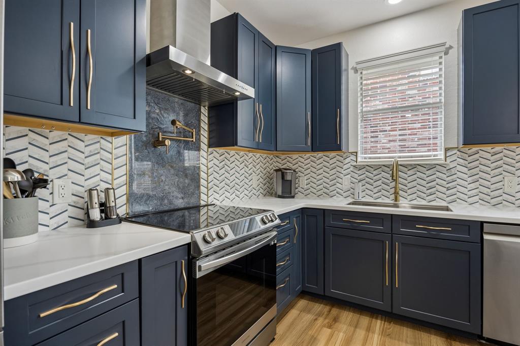 9217 Inverness Drive Rowlett, TX 75089 - Photo 9 of 40 Designer Kitchen Details — Brushed gold fixtures, a pot filler, stainless vent hood, smooth top range, and patterned tile backsplash add a custom feel to this thoughtfully redesigned kitchen.