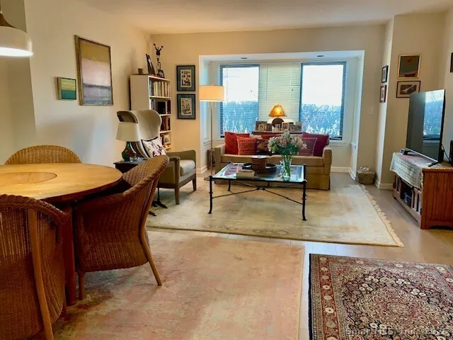 a living room with furniture a flat screen tv and a floor to ceiling window