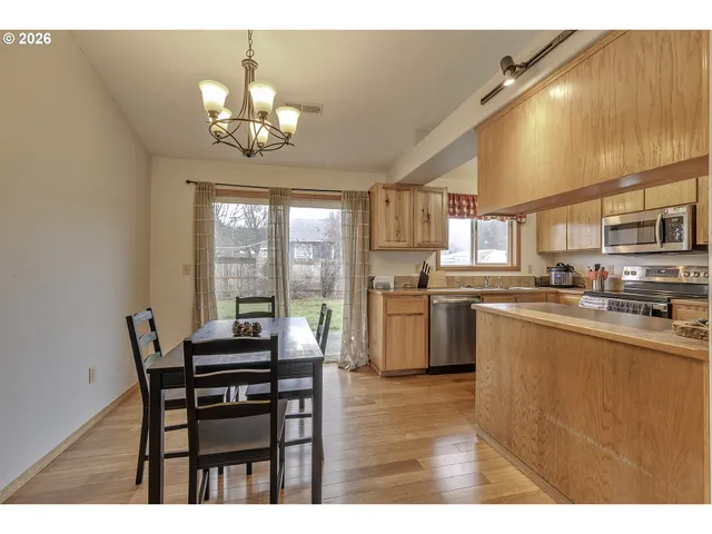 a kitchen with a table chairs refrigerator and microwave