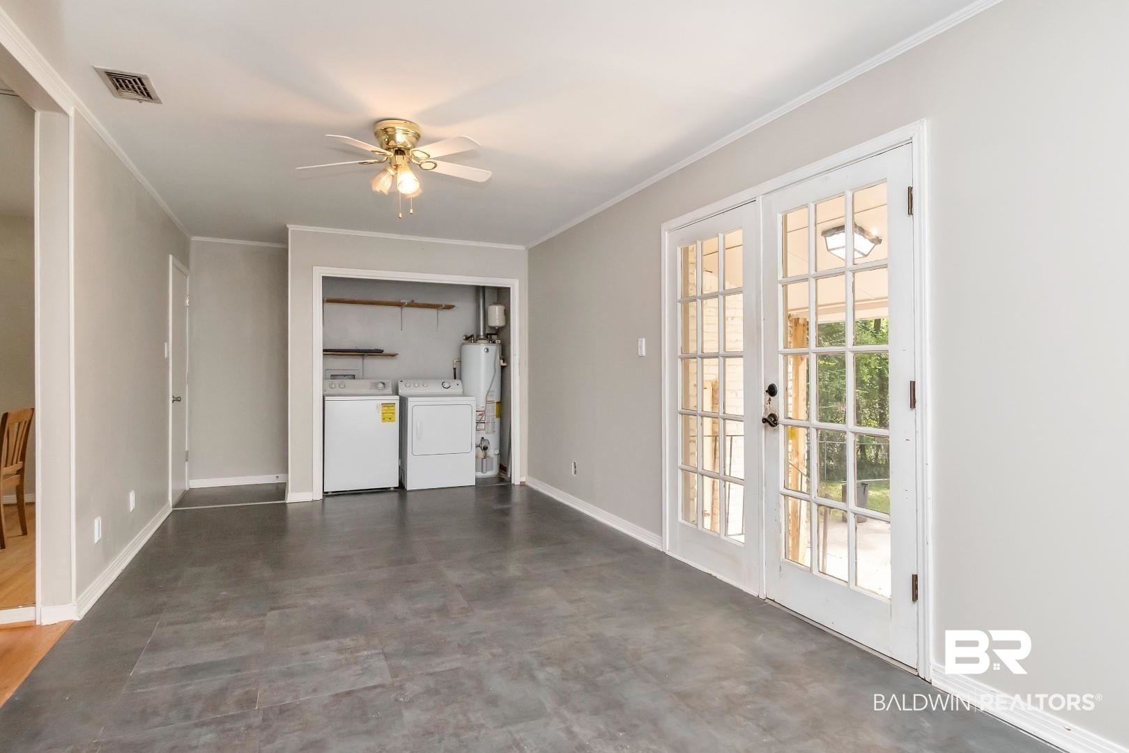 320 Vanderbilt Drive Mobile, AL 36608 - Photo 14 of 39 Unfurnished living room with independent washer and dryer, gas water heater, ornamental molding, and ceiling fan