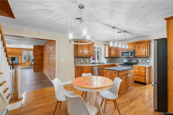 a kitchen with stainless steel appliances wooden floor dining table and chairs